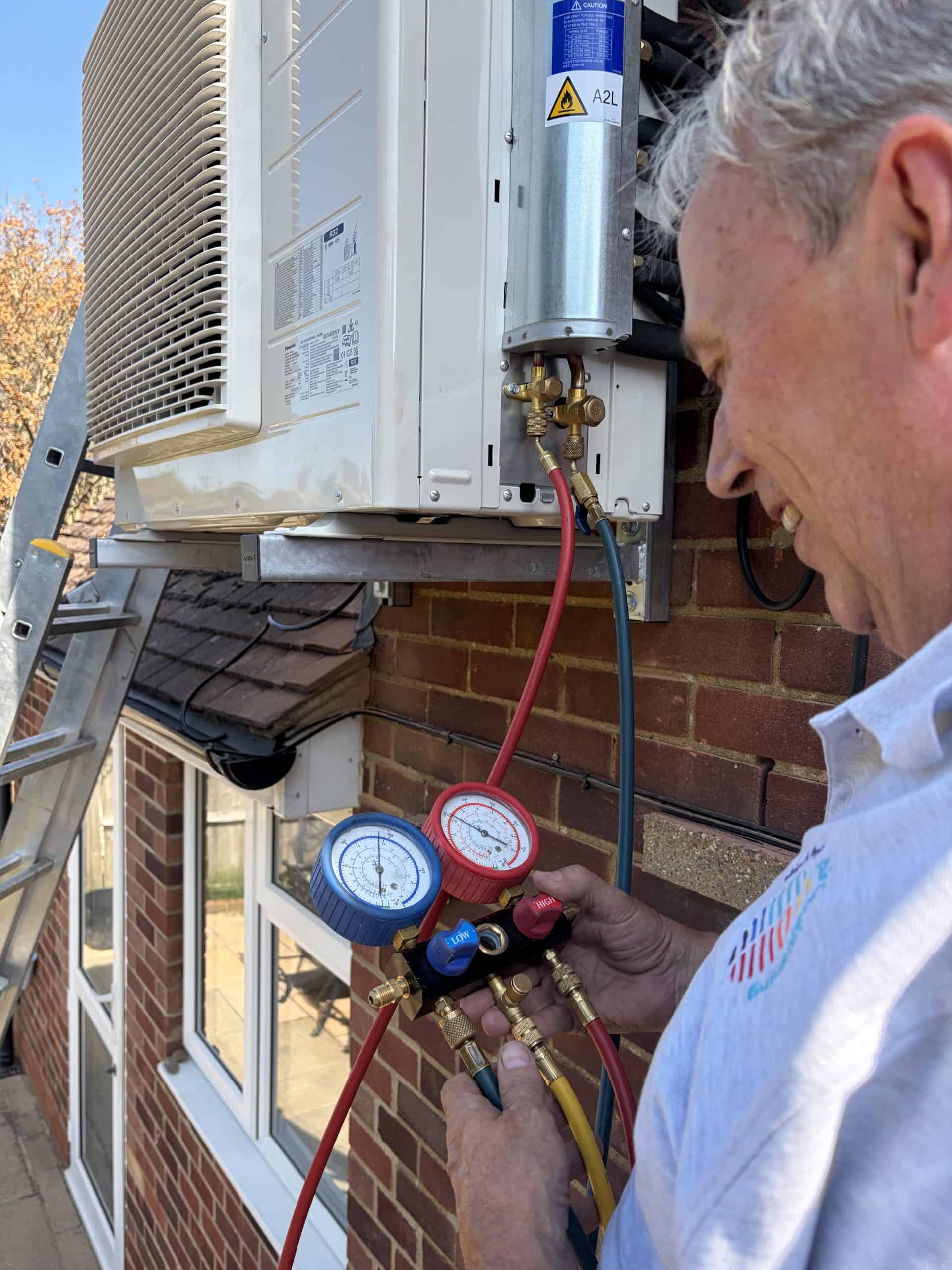 High Path engineer servicing an outdoor air conditioning unit in Godalming